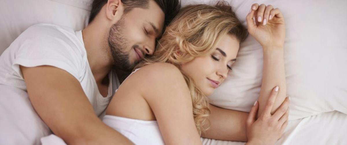 Two adults asleep in bed