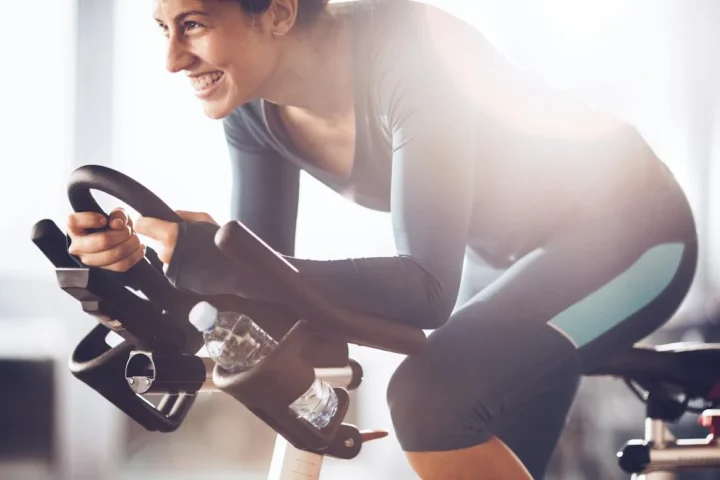 A woman pedaling an indoor stationary bike.