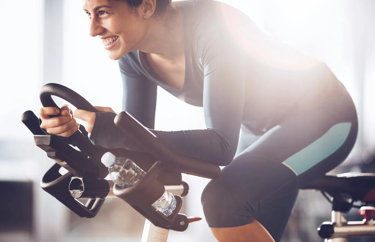 A woman pedaling an indoor stationary bike.