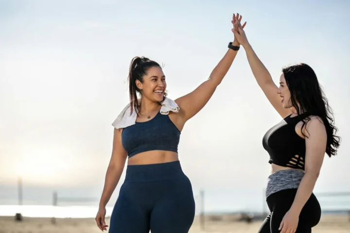 Two women celebrating together after outdoor exercise.