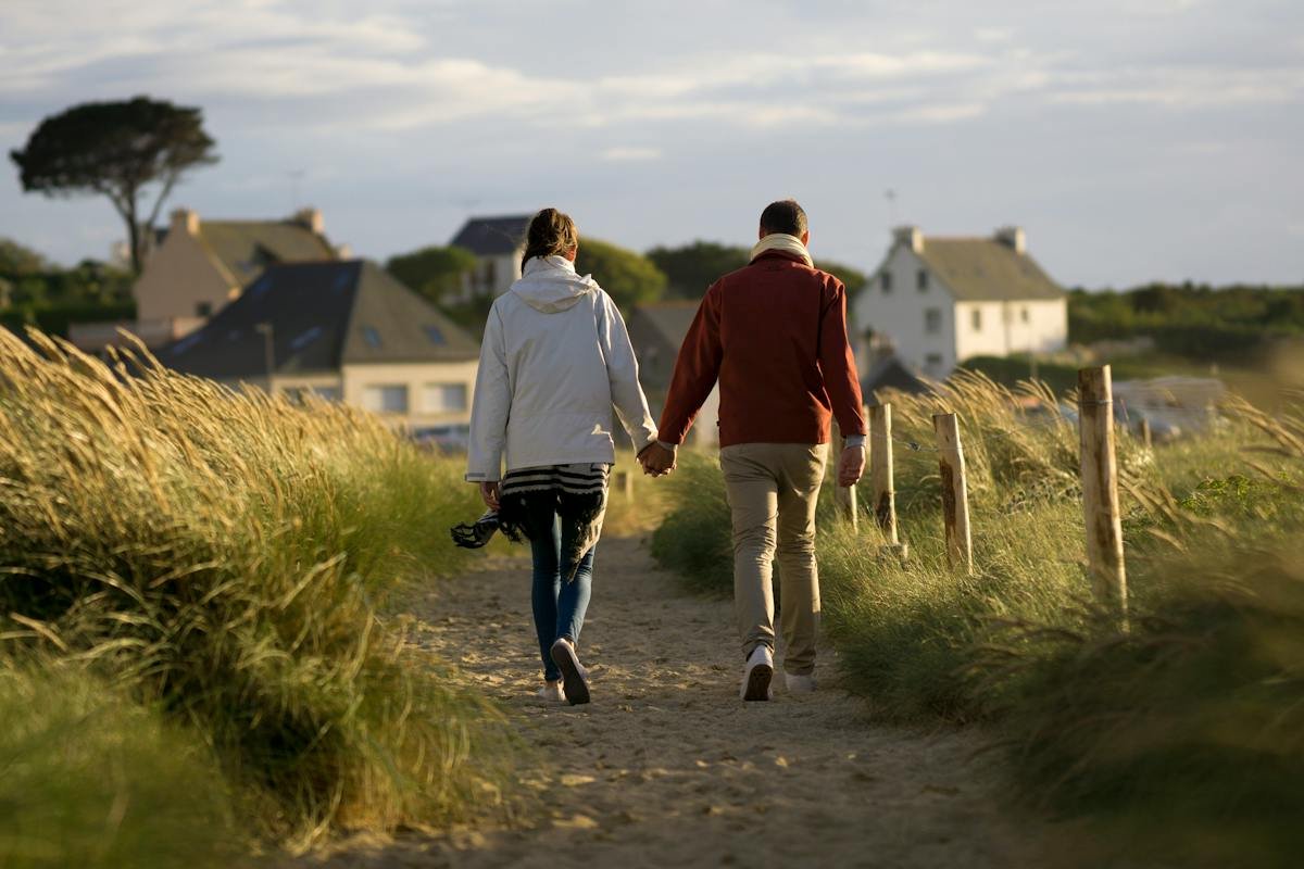 Two people walking along a rural path