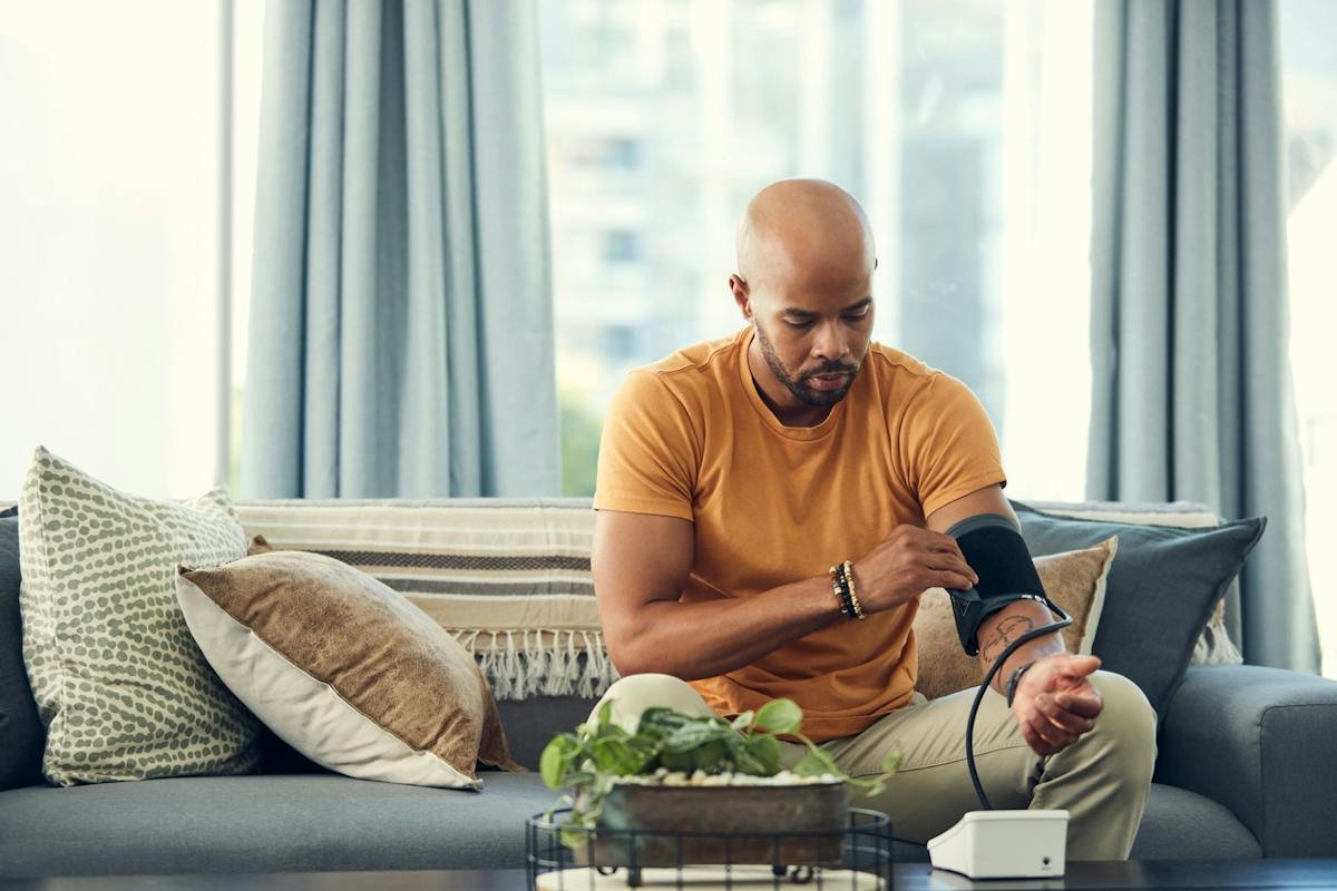 Man checking blood pressure while seated at home