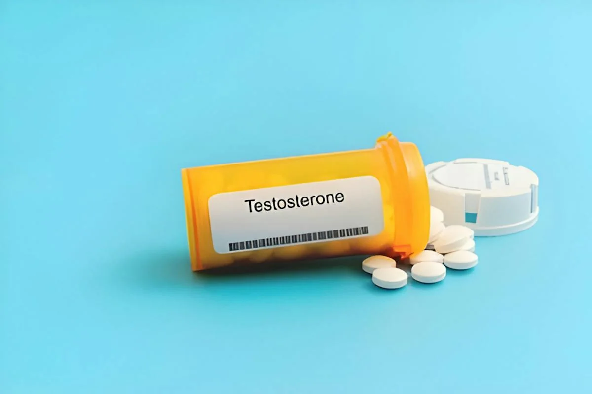 A medication container labeled testosterone beside tablets.