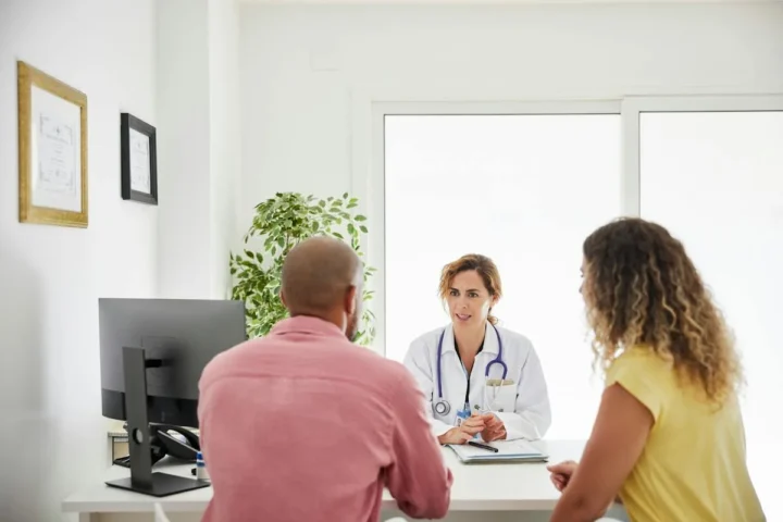 A couple seated across from a clinician during a consultation.