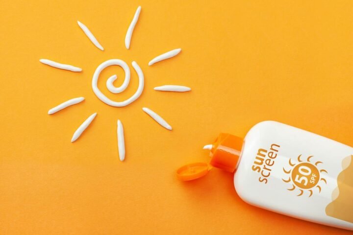 Sunscreen container and a drawn sun on a yellow background